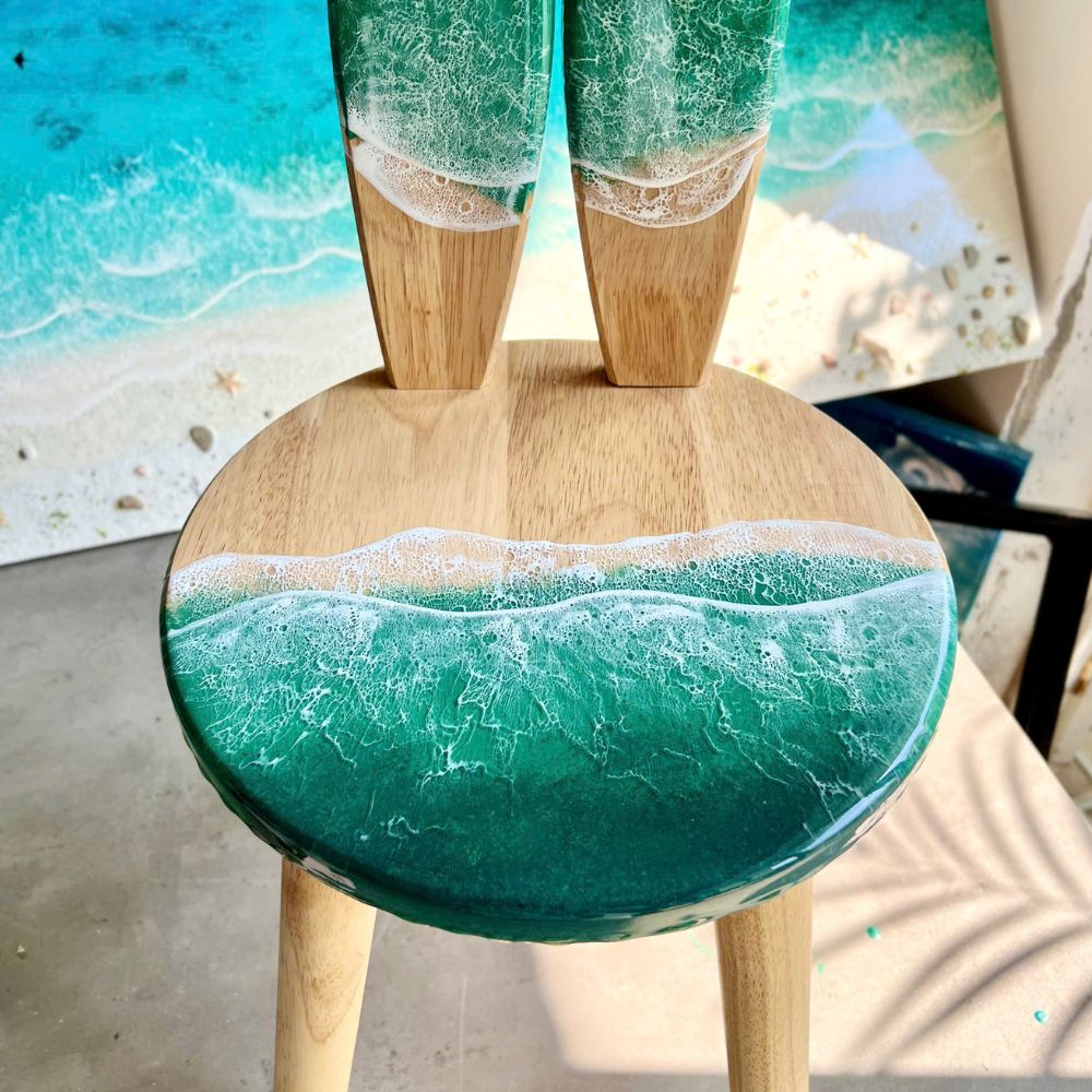 Turquoise resin kids chair seat close-up showing glossy resin finish