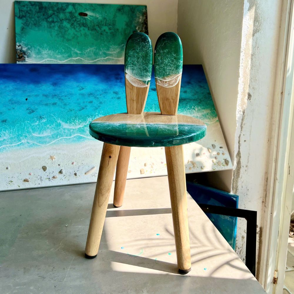 Turquoise resin kids chair side profile showing wood legs
